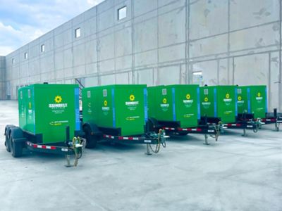 Battery energy storage systems lined up outside of a building.
