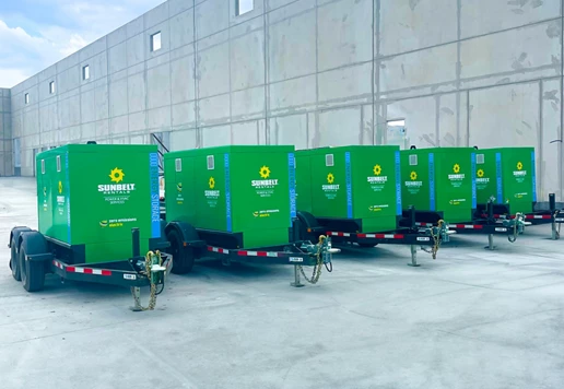 Battery energy storage systems lined up outside of a building.
