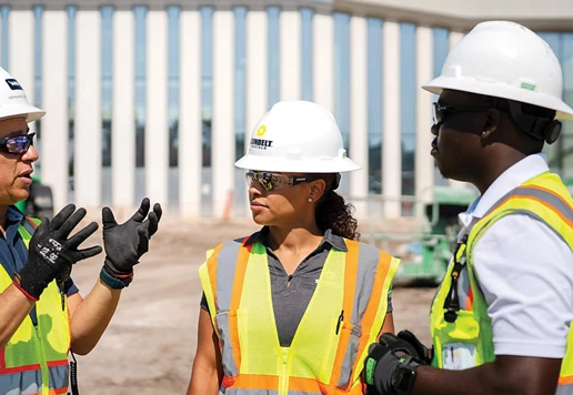 A team wearing safety equipment talking at a jobsite.