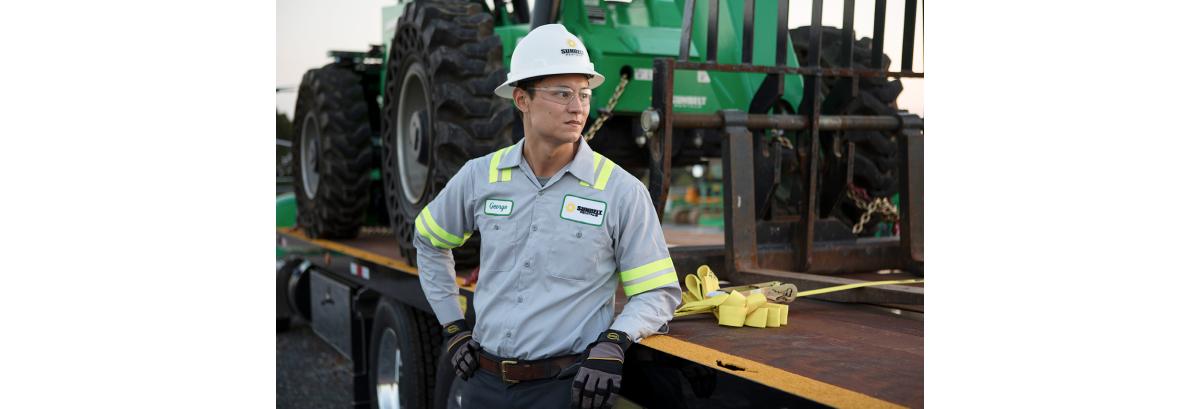 Sunbelt Rentals employee standing in front of a telehandler. 