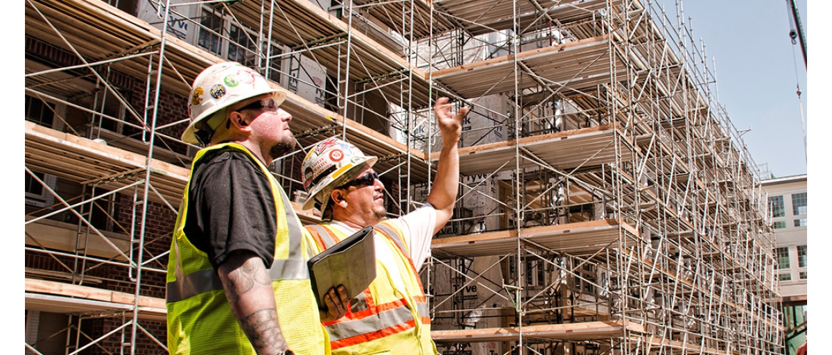Construction workers at a job site with scaffolding.