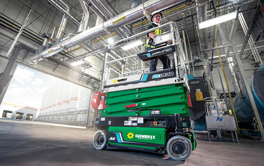 A scisscor lift from Sunbelt Rentals inside of a large building.