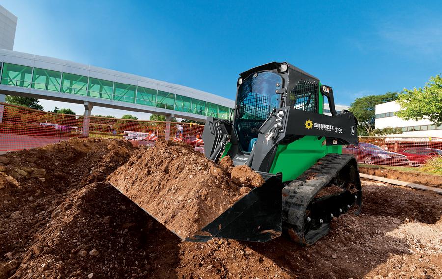 A skid steer loader from Sunbelt Rentals moving dirt at a construction site.
