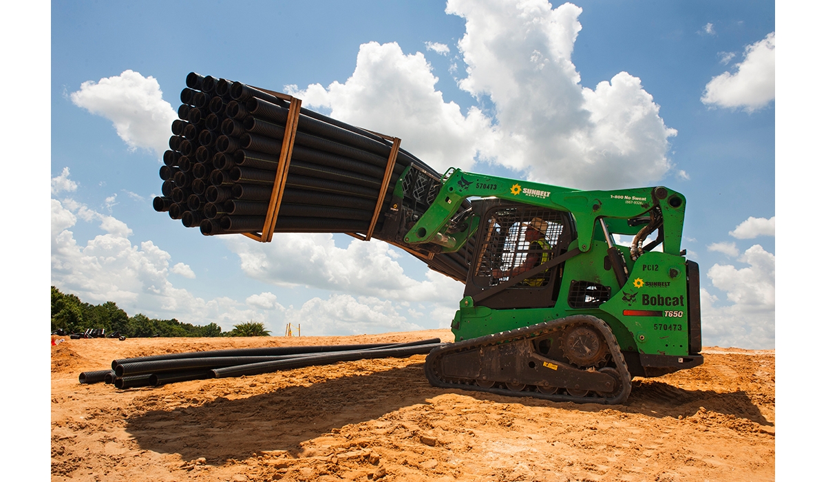 A skid steer loader transporting materials at a job site.