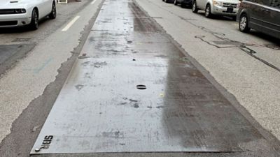 A close-up of road plates on a street.