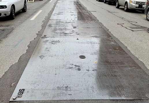 A close-up of road plates on a street.