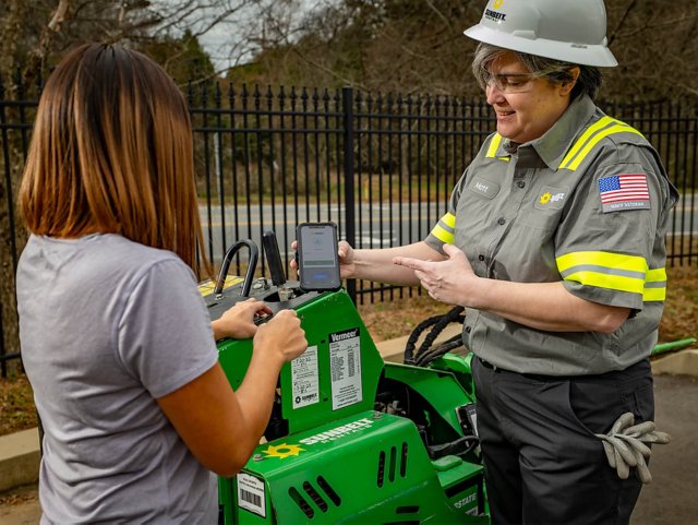 A Sunbelt Rentals employee showing someone MyAccount on a mobile phone.