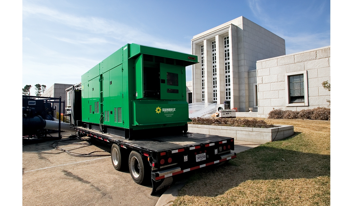 A generator on a trailer outside of a building.
