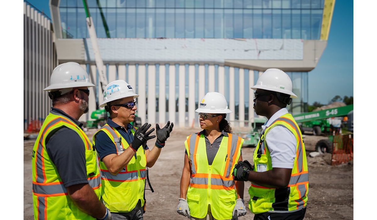 Sunbelt Rentals workers discussing plans at a job site.