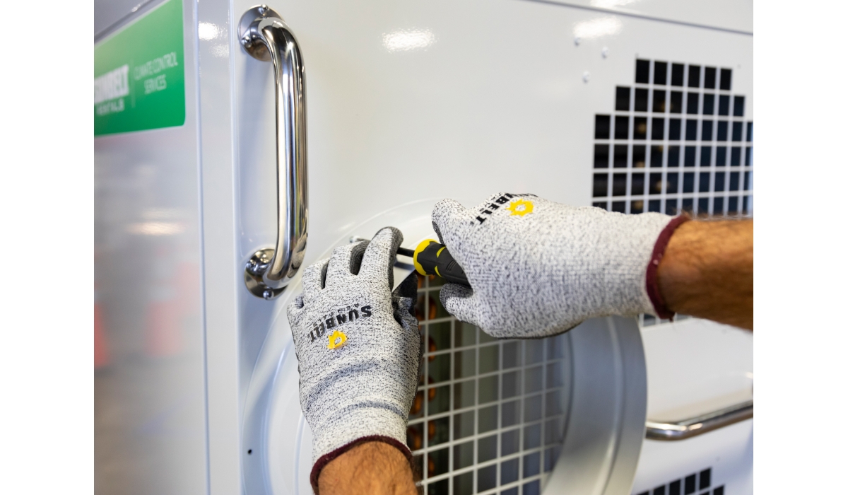 Sunbelt Rentals worker performing maintenance on a portable air conditioner unit.