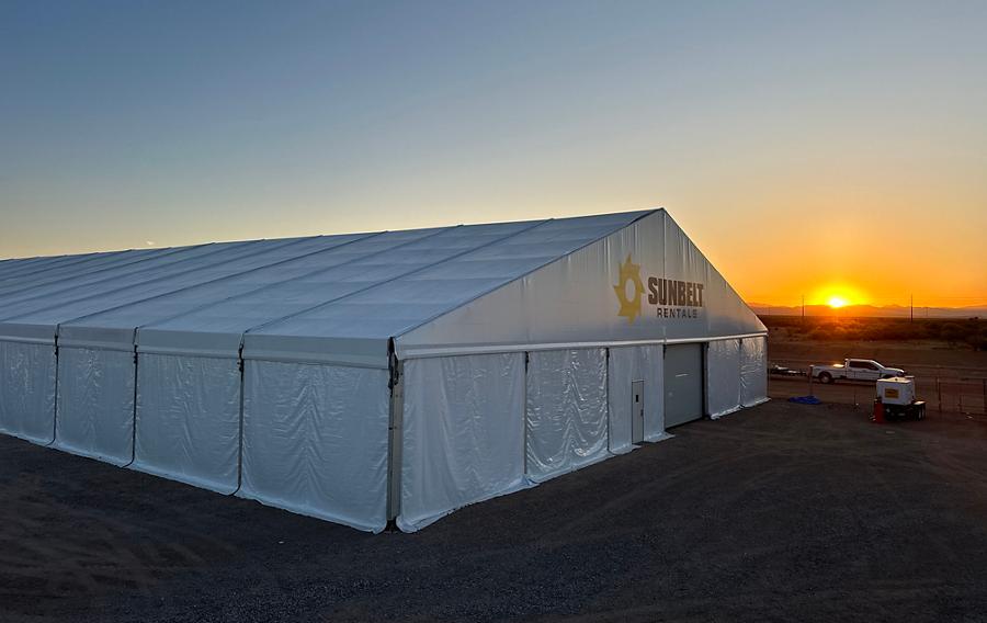 A fabric structure from Sunbelt Rentals at a job site, during sunrise.