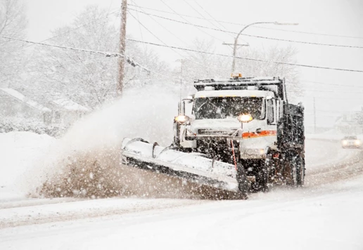 A truck shoveling snow on a road.