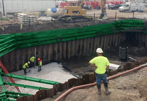 People wearing safety apparel work in and around a sheet and frame system.