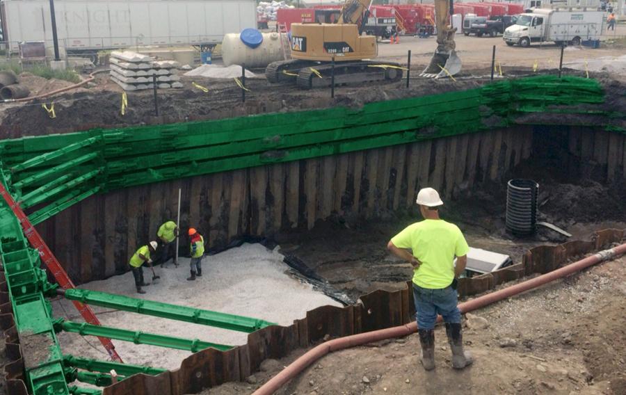 People wearing safety apparel work in and around a sheet and frame system.