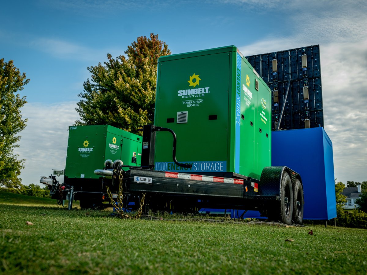 Two Sunbelt Rentals energy storage units on a grassy field.