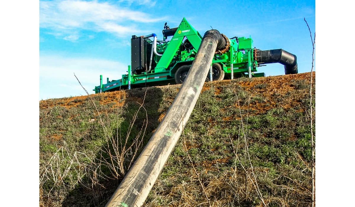 Water removal pump outside on a grassy hill.