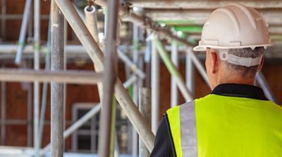 A close-up view of someone standing around scaffolding.